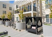 Thumbnail 43 of 78 - A patio with a black and white striped couch and a table.
