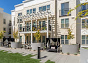 Thumbnail 42 of 78 - A modern building with a white facade and a balcony with a pergola.