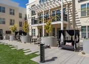 Thumbnail 40 of 78 - A modern outdoor seating area with a black swing chair and a white cushion.
