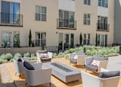 Thumbnail 37 of 78 - A patio with grey chairs and a fire pit.