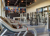 Thumbnail 36 of 78 - A gym with a variety of equipment including treadmills, weights, and exercise machines.