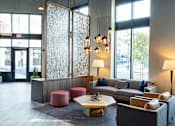 Thumbnail 31 of 78 - A modern waiting room with a glass partition and comfortable seating.