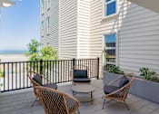Thumbnail 20 of 78 - A balcony with a table and chairs overlooking the ocean.