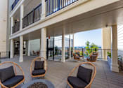 Thumbnail 16 of 78 - A balcony with a table and chairs overlooking the ocean.