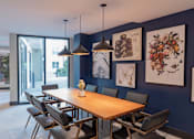 Thumbnail 12 of 78 - A dining room with a wooden table and chairs.