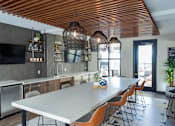 Thumbnail 11 of 78 - A modern kitchen with a long table and chairs.