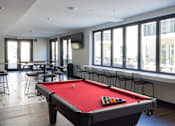 Thumbnail 9 of 78 - A pool table is in the middle of a room with a TV and a row of chairs.