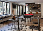 Thumbnail 6 of 78 - A room with a pool table and bar stools.