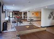 Thumbnail 4 of 78 - A ping pong table is in the middle of a room with a lot of furniture.