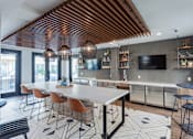 Thumbnail 1 of 78 - A modern kitchen with a long white table and chairs.