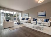 Thumbnail 2 of 14 - A living room with a large window, a white sofa, a glass coffee table, and a rug at The Pier at Sausalito, Sausalito, CA