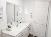 Thumbnail 5 of 9 - A white bathroom with a sink and mirror.