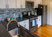 Thumbnail 6 of 10 - a kitchen with granite counter tops and stainless steel appliances