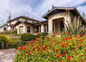 Thumbnail 7 of 10 - a house with a driveway and flowers in front of it