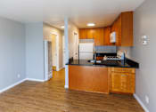 Thumbnail 3 of 9 - A kitchen with wooden cabinets and a black countertop.