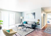 Thumbnail 2 of 9 - A living room with a grey couch and a black and white rug.
