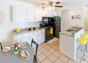 Thumbnail 3 of 8 - A kitchen with a table set for two.