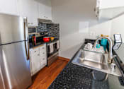 Thumbnail 5 of 8 - A kitchen with a stainless steel refrigerator and a sink.