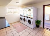 Thumbnail 6 of 8 - A laundry room with a washing machine and dryer stacked on top of each other.