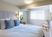 Thumbnail 2 of 11 - A bedroom with a large bed and a chair.