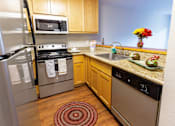 Thumbnail 4 of 9 - A kitchen with a refrigerator, oven, and microwave.