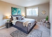 Thumbnail 2 of 9 - A bedroom with a large bed and a painting on the wall.