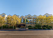 Thumbnail 9 of 9 - A row of apartment buildings with trees in front.