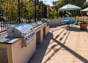 Thumbnail 7 of 9 - A patio with a grill and chairs.