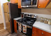 Thumbnail 4 of 8 - A black stove top oven with two pot lids on it.