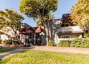 Thumbnail 6 of 6 - A building with a red awning is surrounded by trees and greenery.