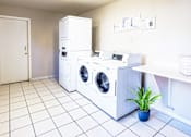 Thumbnail 4 of 6 - A laundry room with a white tiled floor and a white door.