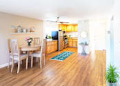 Thumbnail 3 of 9 - A dining room with a table and chairs.