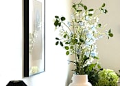 Thumbnail 6 of 14 - A table with a lamp, a vase, and a book on it.