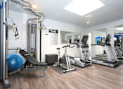 Thumbnail 6 of 9 - a gym with treadmills and other exercise equipment in a room with a mirror