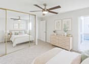 Thumbnail 3 of 11 - A bedroom with a bed, dresser, and mirror.