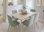 Thumbnail 2 of 11 - A dining room with a table and chairs.