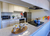 Thumbnail 4 of 10 - a kitchen with white cabinets and a counter top