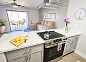 Thumbnail 5 of 10 - A modern kitchen with a large island and a stove top oven.