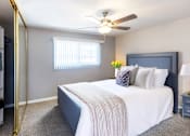 Thumbnail 2 of 9 - A bedroom with a bed, a ceiling fan, and a window with blinds.