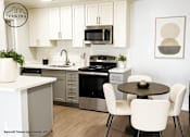 Thumbnail 2 of 14 - A modern kitchen with white cabinets and a black stove top oven.