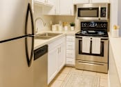 Thumbnail 8 of 14 - A kitchen with a black fridge and stove.