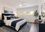 Thumbnail 4 of 14 - A bedroom with a large bed and a ceiling fan.