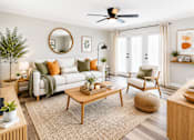 Thumbnail 1 of 12 - A living room with a white couch, a wooden coffee table, and a round mirror on the wall.