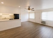 Thumbnail 2 of 19 - A spacious room with a ceiling fan and wooden flooring.