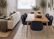 Thumbnail 2 of 13 - A dining room with a table and chairs.