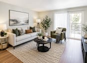 Thumbnail 1 of 12 - A living room with a white couch, a black coffee table, and a painting on the wall.