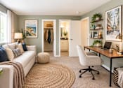 Thumbnail 5 of 12 - A cozy living room with a couch, a chair, a desk, and a rug.