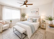 Thumbnail 6 of 12 - A bedroom with a large bed, a chair, and a ceiling fan.
