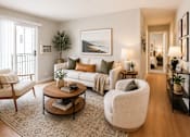 Thumbnail 4 of 12 - A living room with a white sofa, a wooden coffee table, and a large painting on the wall.