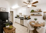 Thumbnail 3 of 12 - A kitchen with a black stove top oven and white cabinets.